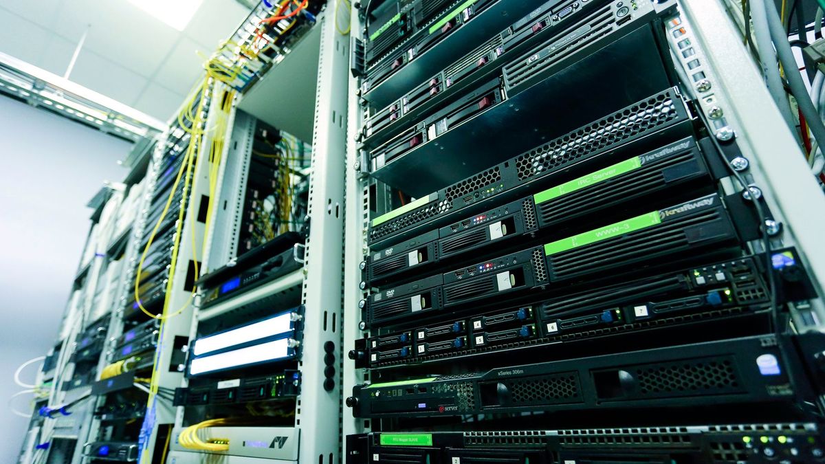 Rows of server racks with network cables in a data centre