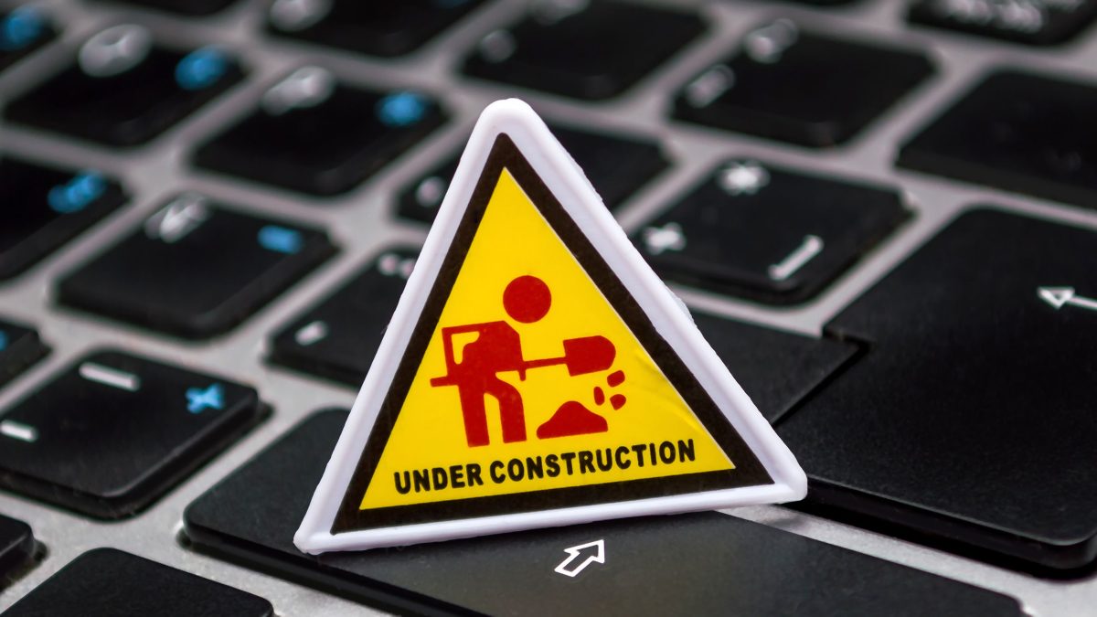 A miniature under construction sign on a laptop keyboard